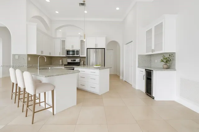 a kitchen with stainless steel appliances granite countertop a refrigerator and a stove top oven