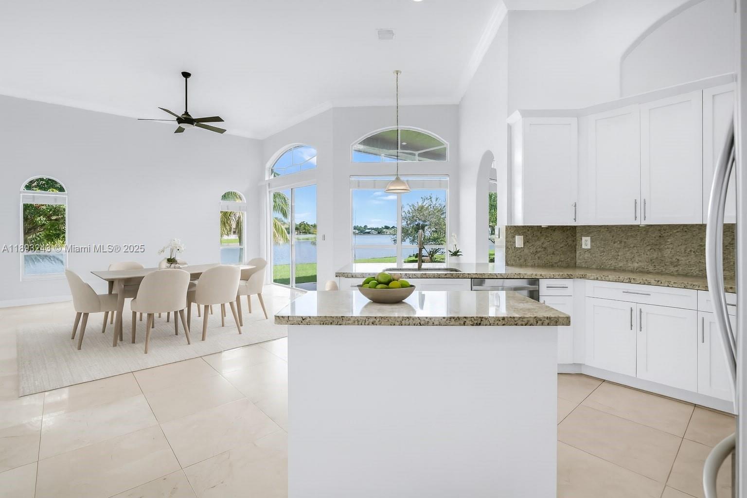 14032 Northwest 15th Street Pembroke Pines, FL 33028 - Photo 6 of 55 a kitchen with stainless steel appliances kitchen island granite countertop a sink a stove a dining table and chairs with wooden floor