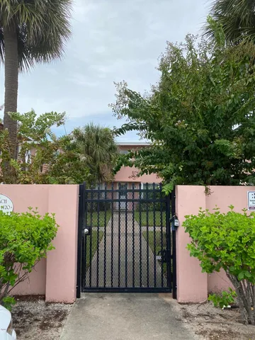 a view of a house with a yard and potted plants