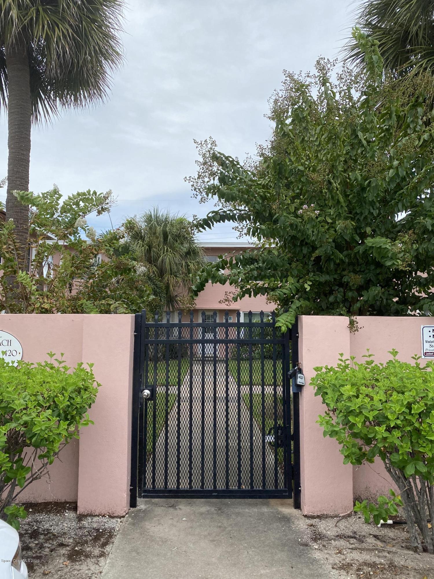 a view of a house with a yard and potted plants