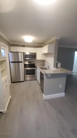a room with stainless steel appliances a stove a refrigerator and a sink