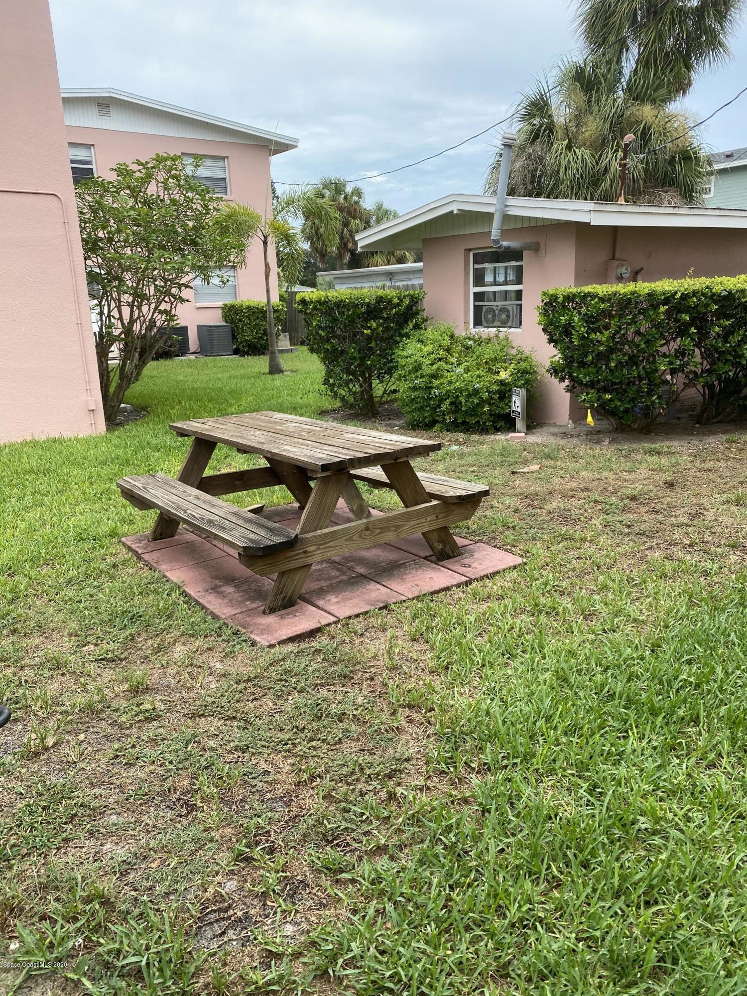 420 Monroe Avenue, Unit 101 Cape Canaveral, FL 32920 - Photo 27 of 35 a view of a house with a yard and a patio
