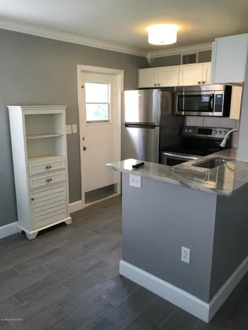 a kitchen with kitchen island a refrigerator sink and stove