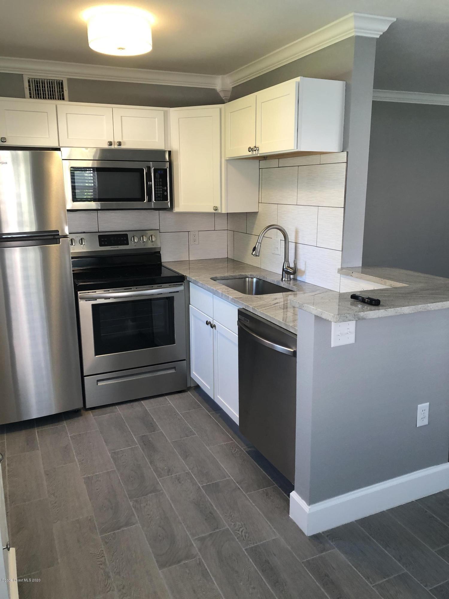 420 Monroe Avenue, Unit 101 Cape Canaveral, FL 32920 - Photo 7 of 35 a kitchen with a sink stove and microwave