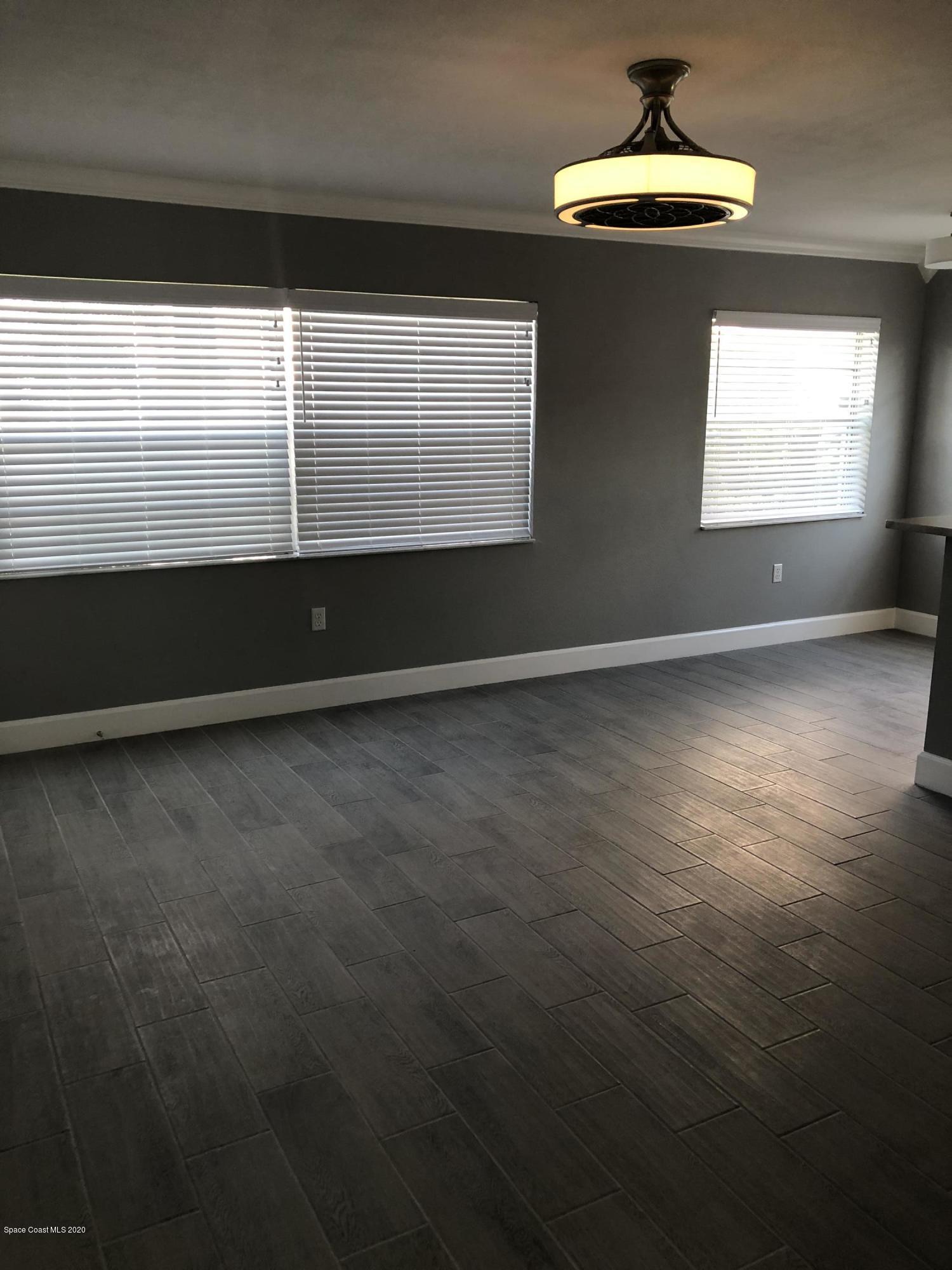 420 Monroe Avenue, Unit 101 Cape Canaveral, FL 32920 - Photo 10 of 35 a view of an empty room with wooden floor and a window