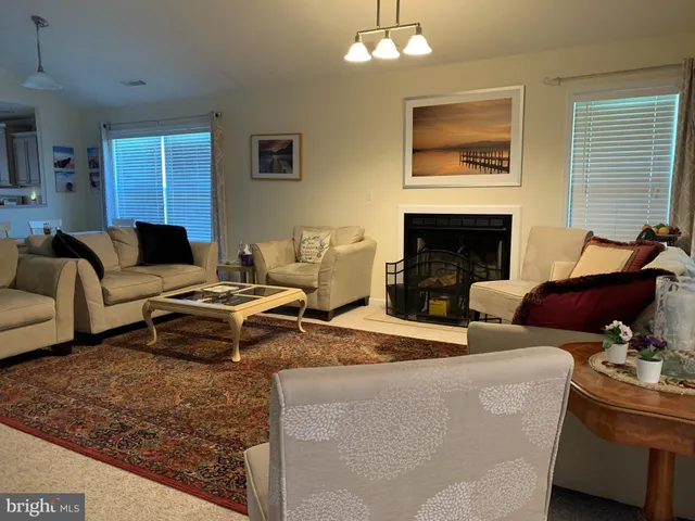 a living room with furniture a fireplace and a window