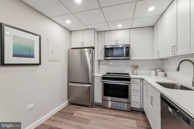 a kitchen with a sink stainless steel appliances and cabinets