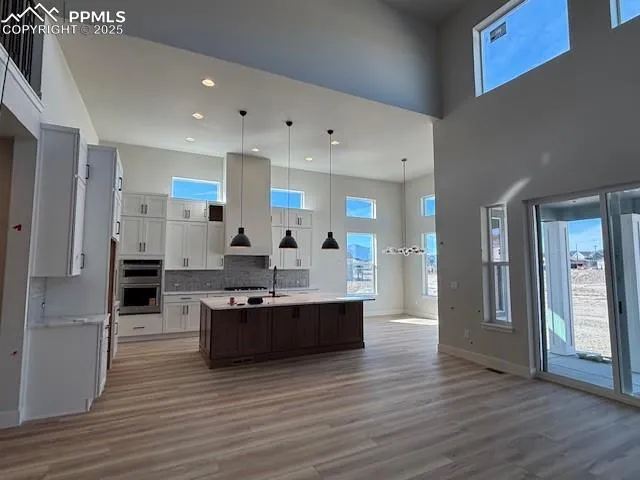 a large kitchen with stainless steel appliances a large counter top a sink and a refrigerator