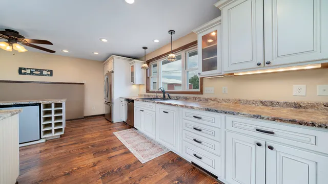 a kitchen with stainless steel appliances granite countertop a stove and a sink with cabinets
