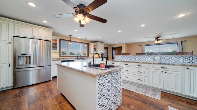 a kitchen with granite countertop a sink stainless steel appliances and counter space