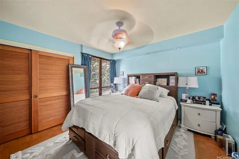 a bedroom with a bed and wooden floor
