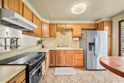 a kitchen with stainless steel appliances granite countertop a refrigerator a sink and a stove