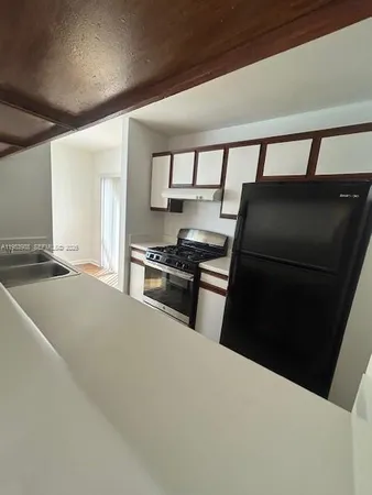 a kitchen with granite countertop a refrigerator and a stove