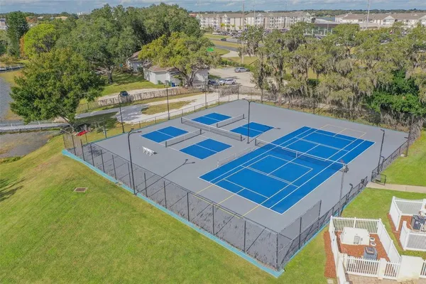 a view of a tennis court with a large pool and couches