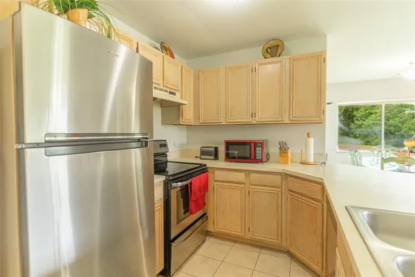 a kitchen with stainless steel appliances granite countertop a refrigerator sink and white cabinets