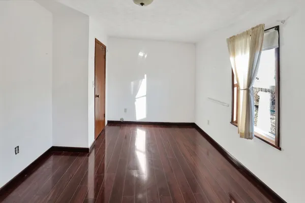 a view of a room with wooden floor and window