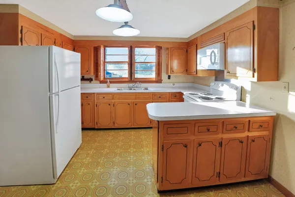 a kitchen with stainless steel appliances granite countertop a sink a stove a refrigerator a washer dryer and white cabinets