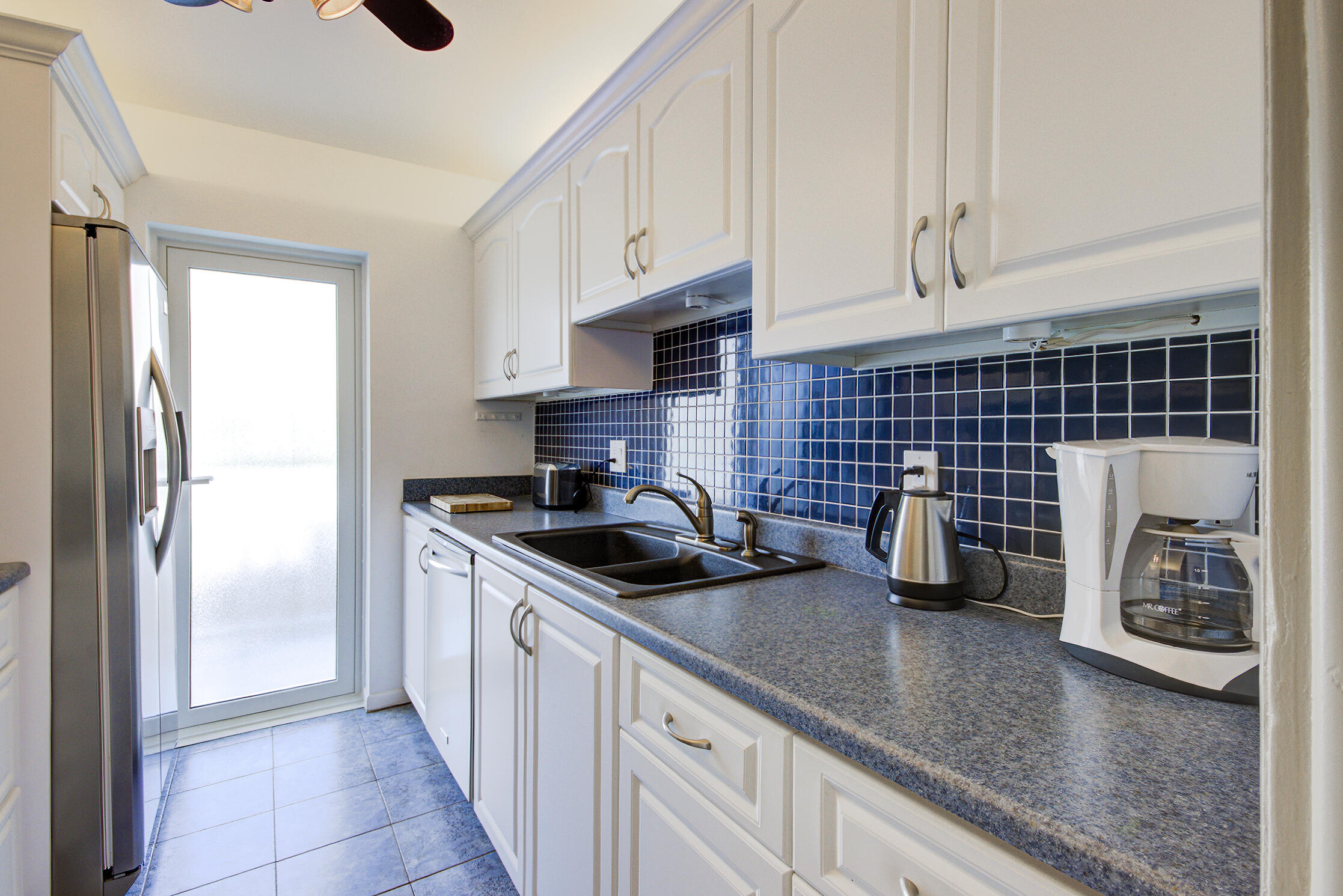 3100 South Ocean Boulevard, Unit 216 Highland Beach, FL 33487 - Photo 11 of 34 a kitchen with granite countertop a sink stove and cabinets