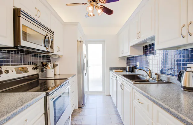 a kitchen with granite countertop a sink stove and cabinets