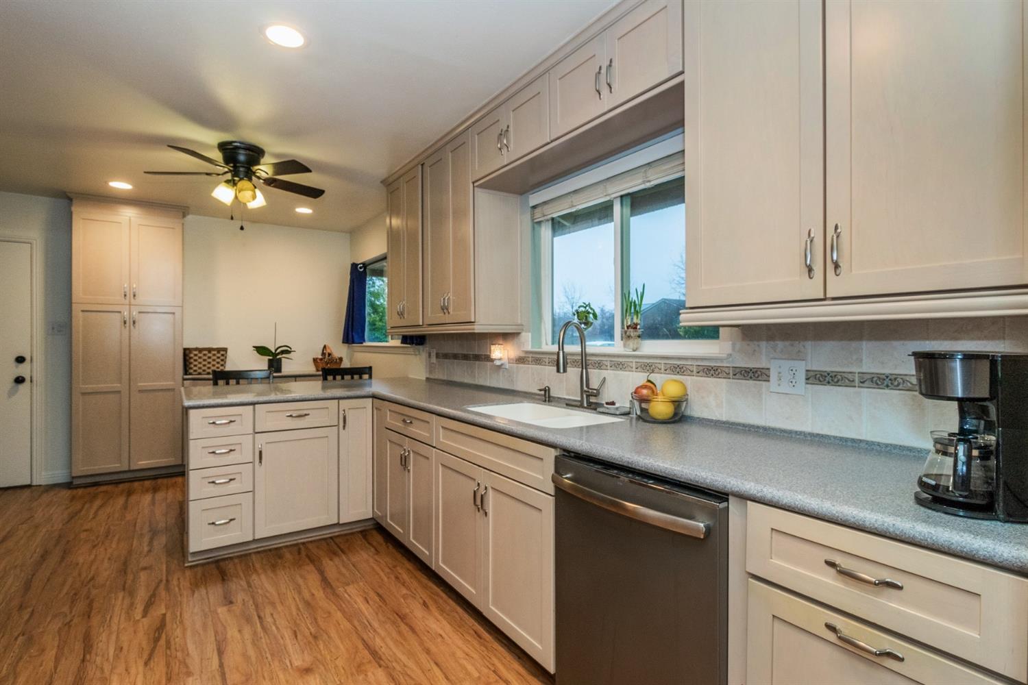 1783 North De Wolf Avenue Clovis, CA 93619 - Photo 9 of 39 a kitchen with stainless steel appliances granite countertop a sink dishwasher a stove and white cabinets with wooden floor