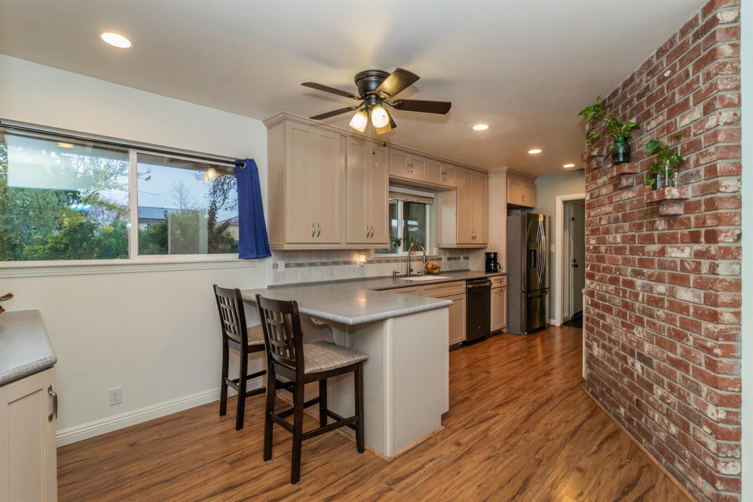 1783 North De Wolf Avenue Clovis, CA 93619 - Photo 10 of 39 a kitchen with a table chairs refrigerator and microwave