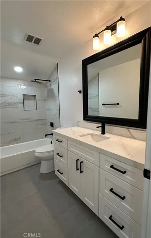 a bathroom with a double vanity sink and mirror with bathtub
