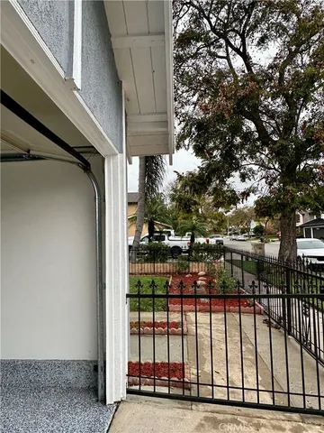 a view of a backyard with brick wall and large trees