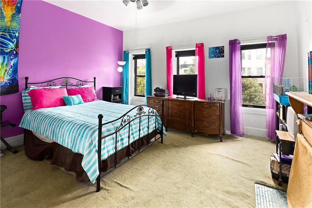 677 Saint Marks Avenue Brooklyn, NY 11216 - Photo 7 of 18 a bedroom with a bed table and a large window
