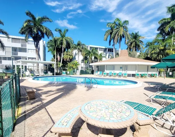 a view of a swimming pool with a patio and a yard