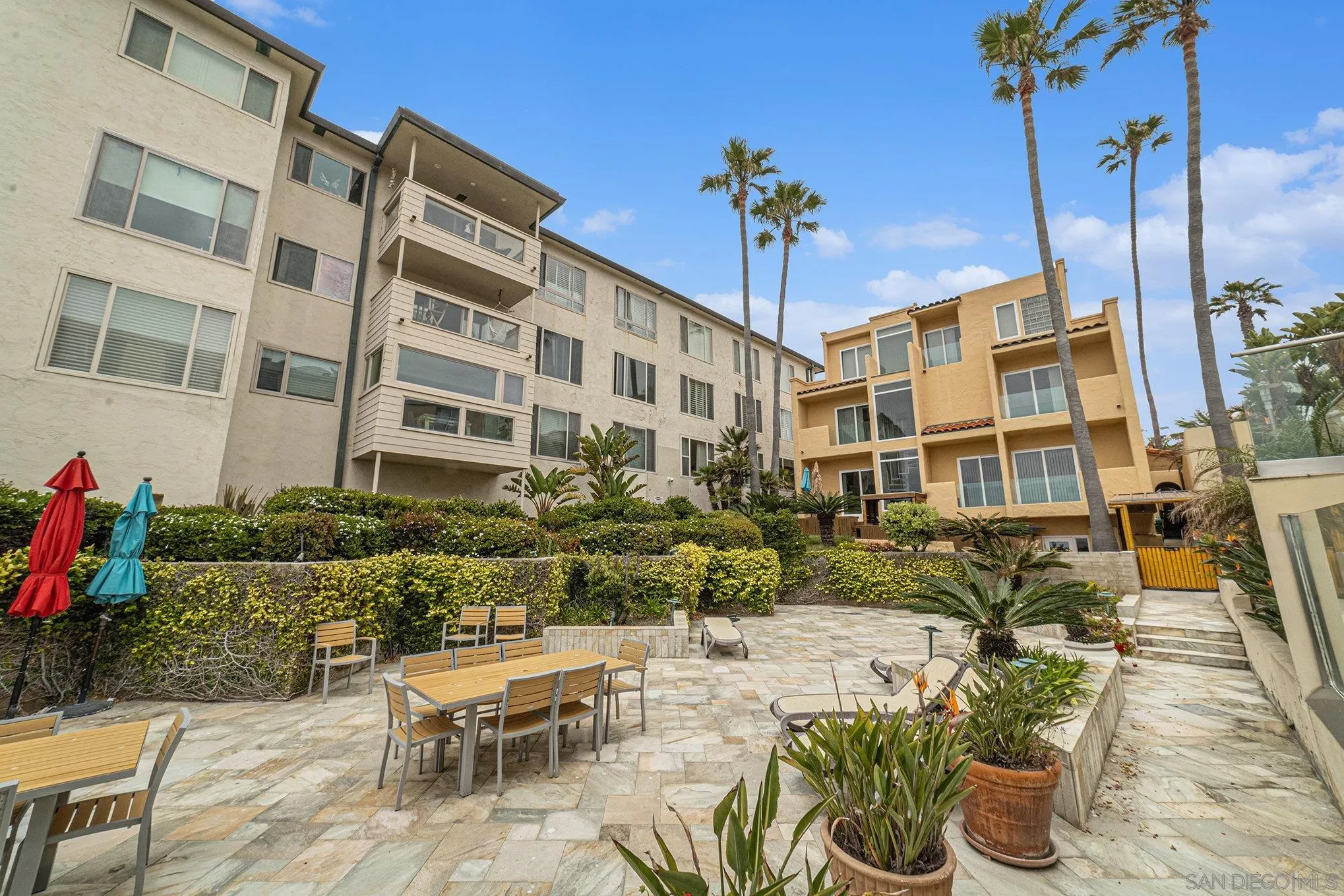 220 Coast Boulevard, Unit 2D La Jolla, CA 92037 - Photo 25 of 35 a view of a patio with dining table and chairs potted plants