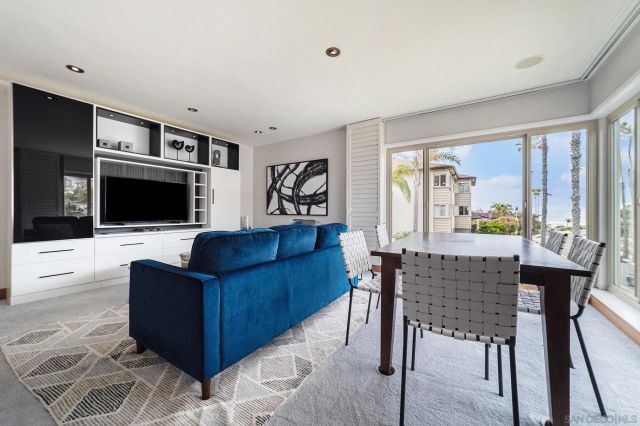 a living room with furniture a flat screen tv and a floor to ceiling window
