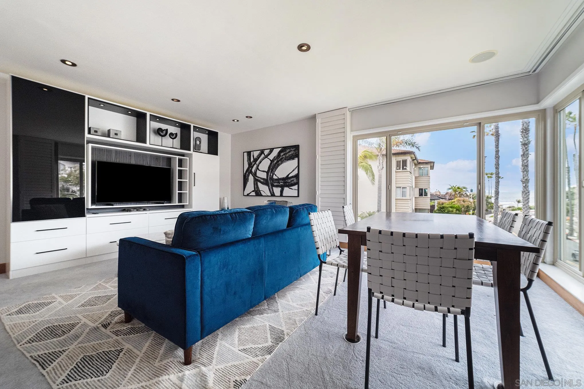220 Coast Boulevard, Unit 2D La Jolla, CA 92037 - Photo 7 of 35 a living room with furniture a flat screen tv and a floor to ceiling window