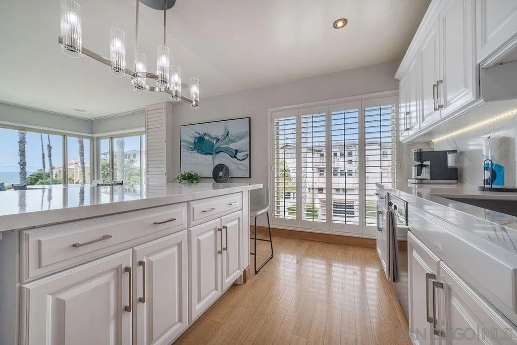220 Coast Boulevard, Unit 2D La Jolla, CA 92037 - Photo 10 of 35 a large kitchen with granite countertop a large window a sink and stainless steel appliances