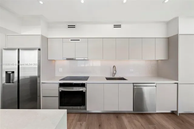 a kitchen with stainless steel appliances granite countertop a stove a refrigerator and a sink