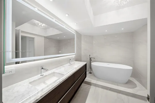 a bathroom with a double vanity sink mirror and bathtub