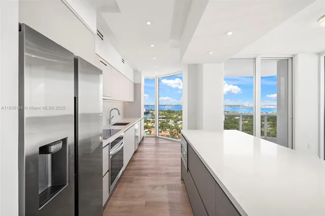 a large kitchen with a large window and stainless steel appliances