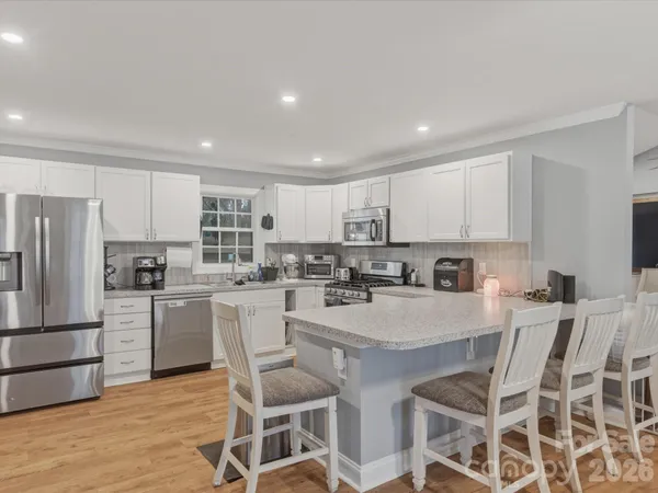 a kitchen with white cabinets stainless steel appliances and refrigerator