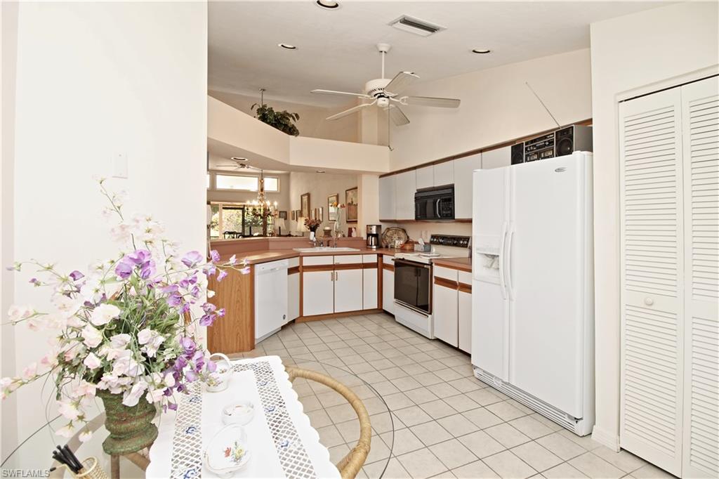 4028 Crayton Road, Unit C3 Naples, FL 34103 - Photo 11 of 32 a kitchen with granite countertop stainless steel appliances and white cabinets