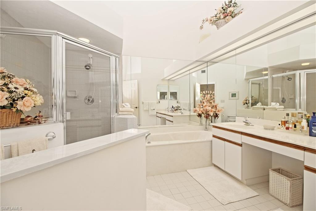 4028 Crayton Road, Unit C3 Naples, FL 34103 - Photo 16 of 32 a large white bathroom with a large mirror vanity sink and bathtub