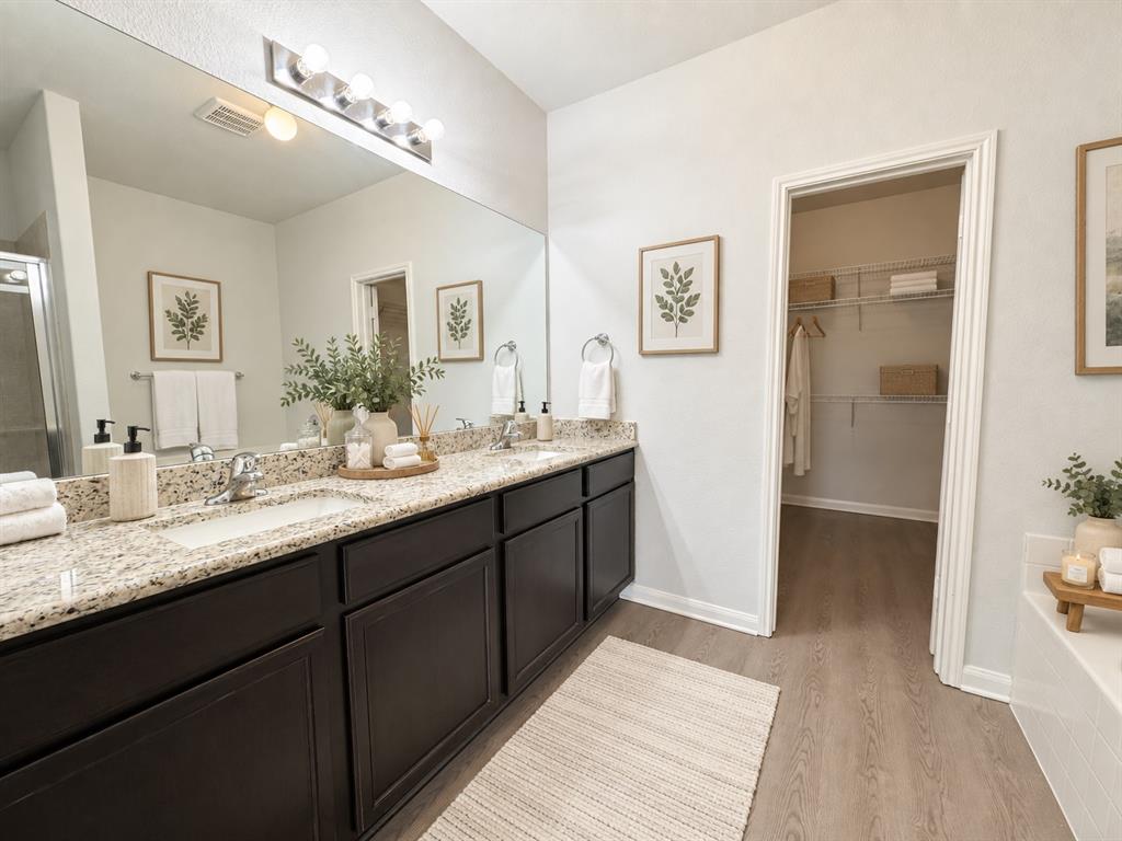 2950 Parker Road Anna, TX 75409 - Photo 6 of 12 Dual vanity with granite-style countertops, dark wood-finish cabinetry, and undermount sinks