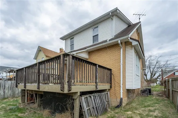 a front view of house along with deck and outdoor seating