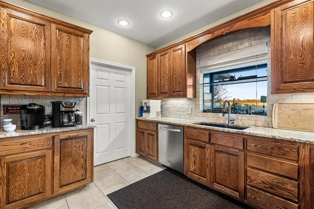 a kitchen with stainless steel appliances granite countertop a stove top oven a sink dishwasher and a microwave oven on the blue kitchen countertops