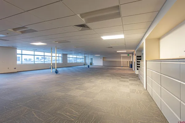 a room with lots of tables a chairs and a potted plant