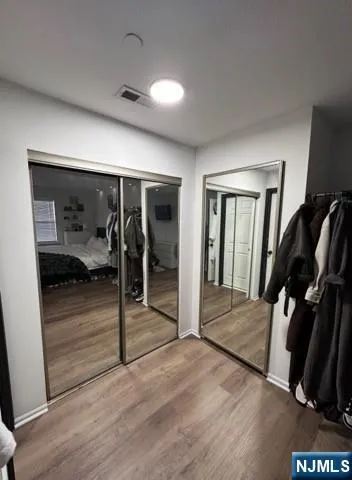a view of a hallway to room with wooden floor and furniture