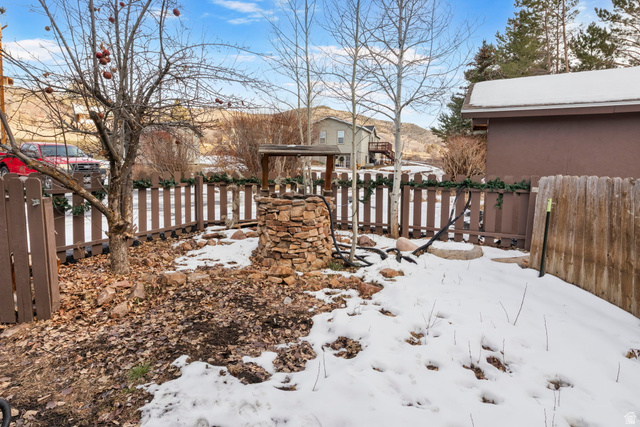 2189 Samak Park Loop, Unit 43 Kamas, UT 84036 - Photo 42 of 48 Fenced outdoor space featuring a stone-clad wishing well, mature tree, and a brown picket fence