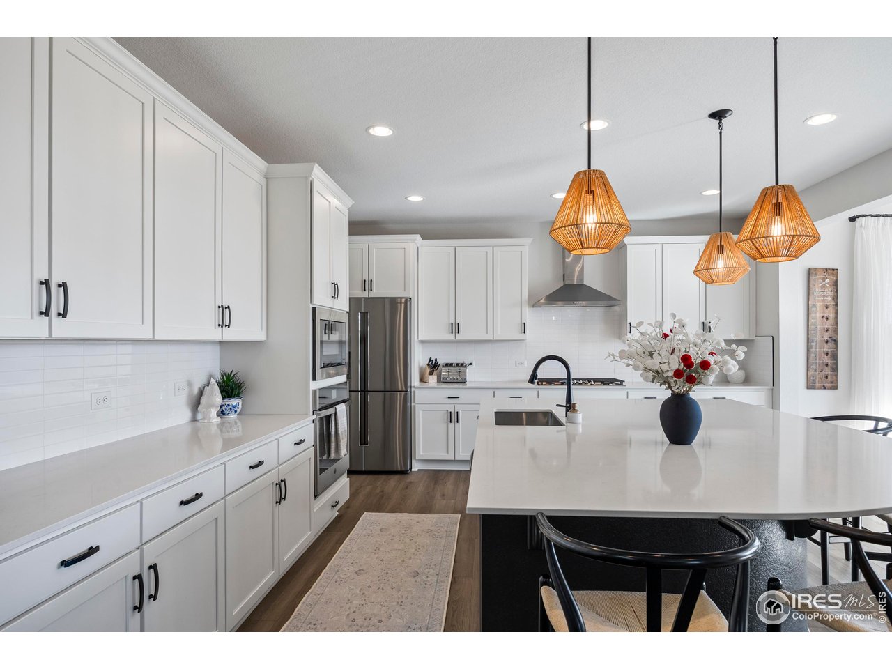 951 Rustling Street Windsor, CO 80550 - Photo 11 of 47 a kitchen with refrigerator a sink a counter space and cabinets