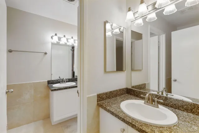 a bathroom with a granite countertop sink and a mirror