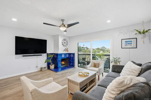 a living room with furniture a flat screen tv and a large window