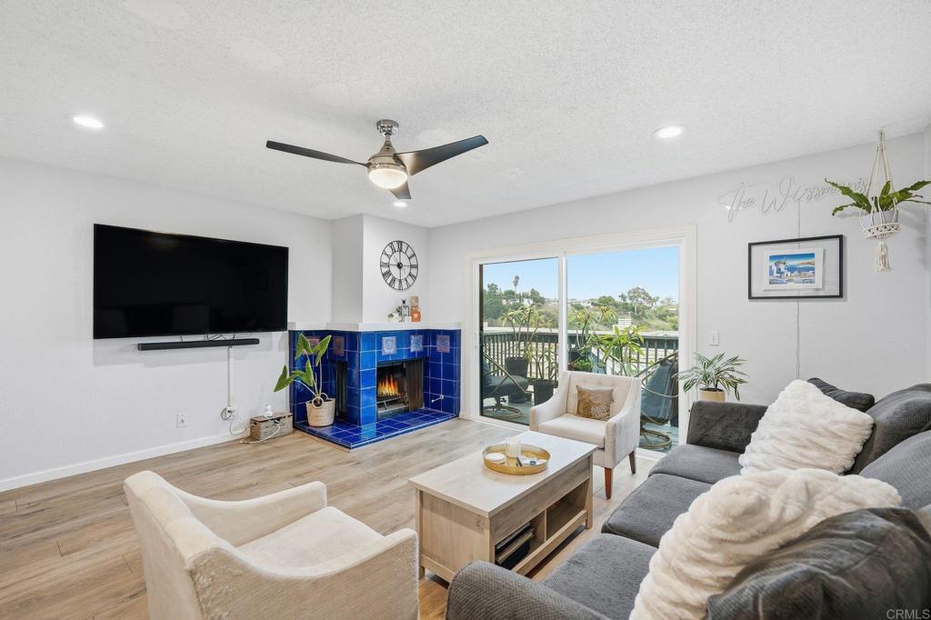 a living room with furniture a flat screen tv and a large window