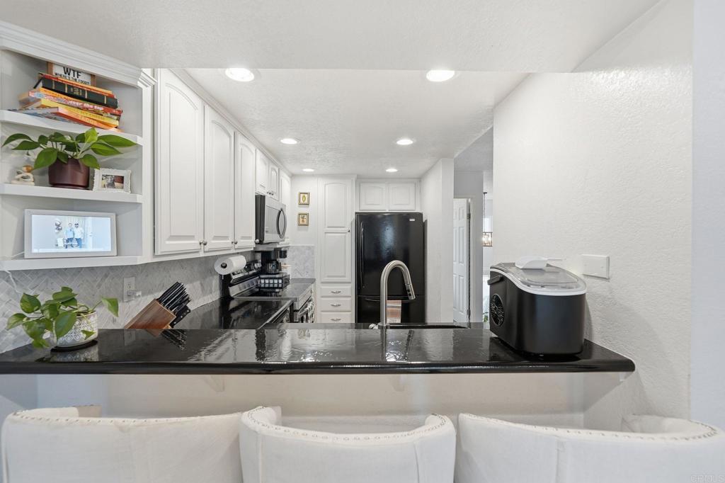 3711 Balboa Terrace, Unit B San Diego, CA 92117 - Photo 11 of 39 a kitchen with a two sinks a stove and a dining table with wooden floor